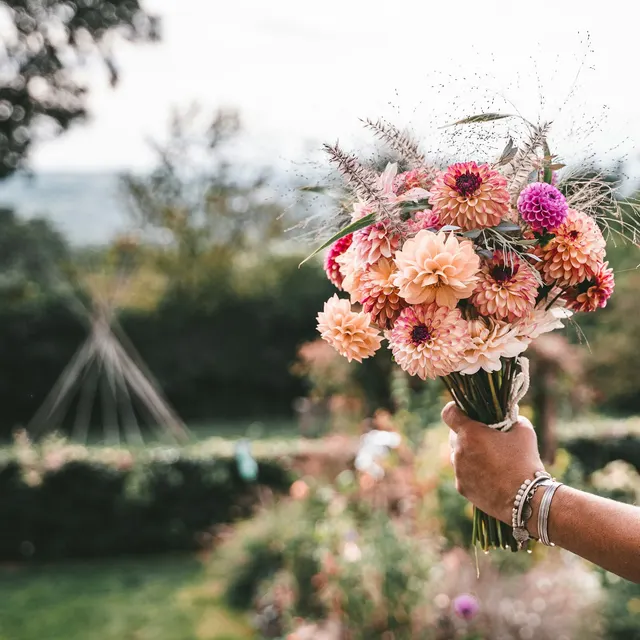 Hand holding a bouquet in a garden